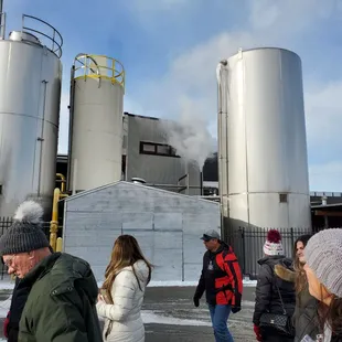 a group of people standing in front of a brewery