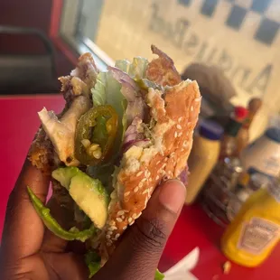 a hand holding a half eaten sandwich