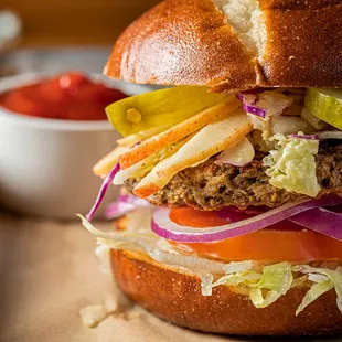 a burger with lettuce, tomato, and pickles