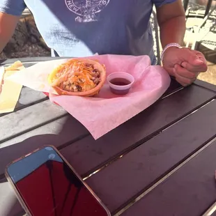 Waffle bowl with eggs, sausage, cheese, and maple syrup