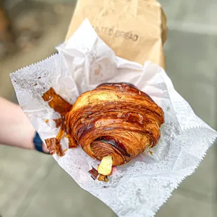 a person holding a croissant