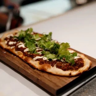 a flatbread pizza on a cutting board