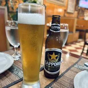 a glass of beer and a bottle of sappor