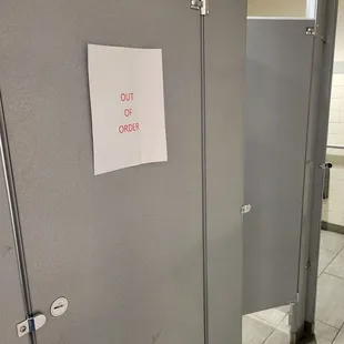 a toilet stall with a sign on it