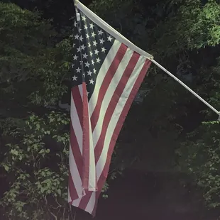 an american flag hanging from a pole
