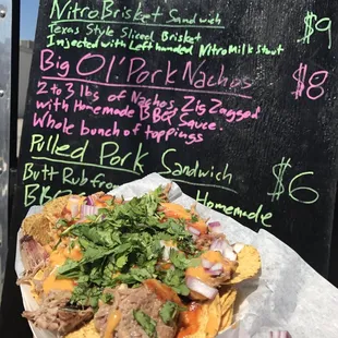  hand holding a plate of nachos