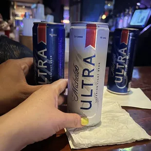 a person holding a can of ultra