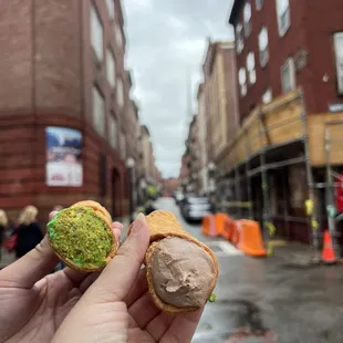 a person holding a sandwich with a bite taken out of it