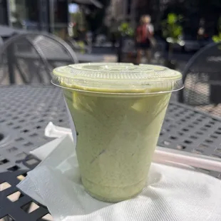 a green smoothie in a plastic cup