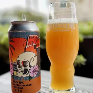 a glass of beer next to a can