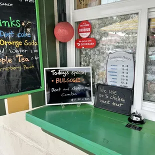a green counter and menu board