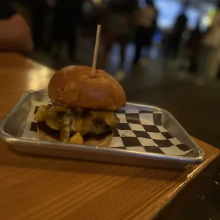 a cheeseburger on a tray on a table