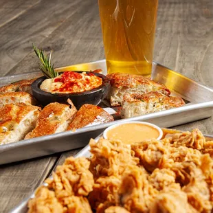 a tray of fried chicken and a glass of beer