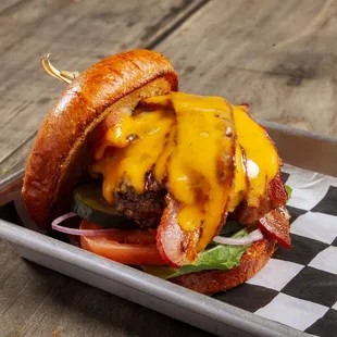 a cheeseburger with bacon, tomato, and lettuce