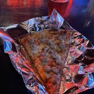 Slice of sausage pizza.  Hot, fast, and tasty!