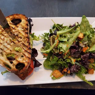 TBLTA (tempeh bacon, greens, tomato, cucumber, guacamole, lemon mayo on toasted sourdough bread) with salad instead of chips