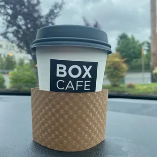 a cup of coffee on the dashboard of a car