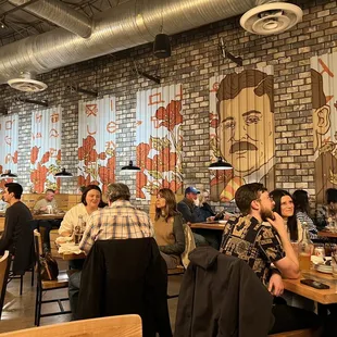 a group of people sitting at tables in a restaurant