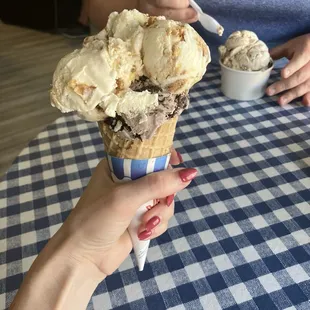 Small waffle cone with ooey gooey butter cake on top of cookies and cream.