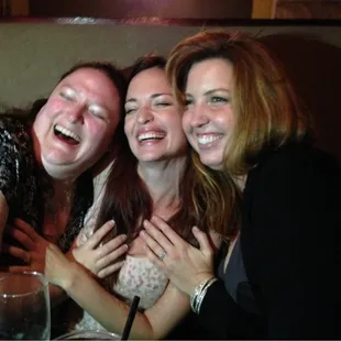 a group of women laughing and posing for a picture
