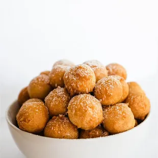 a bowl of sugared doughnuts