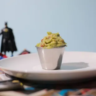a bowl of guacamole on a plate