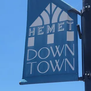 a blue and white banner hanging from a pole