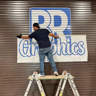 Carefully applying graphics to our storefront!