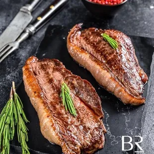 two steaks on a black plate