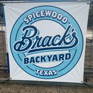 a sign in front of a fence