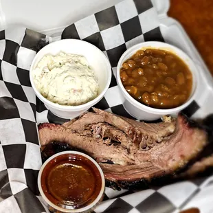 a plate of ribs, beans, and mashed potatoes