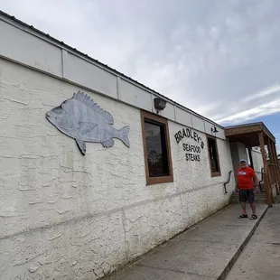 a man standing in front of a restaurant