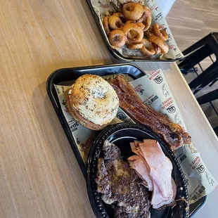 The breakfast smash with onion rings. Everything bagel with smoked cream cheese, breakfast sausage, double smoked ham and candied bacon.