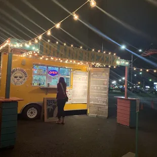 a woman standing in front of a food truck