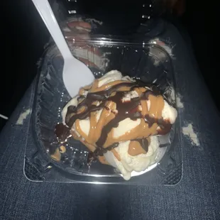 a plastic container with ice cream and caramel