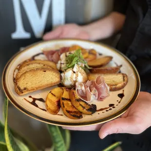 Grilled peaches, burrata, cured meats, and crispy house made crostini.
