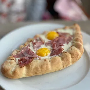 Khachapuri--cheese bread, three cheese fondue, two baked egg yolks with ham