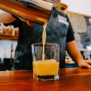 a bartender pouring orange juice