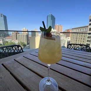 a cocktail on a table overlooking a city