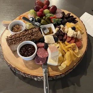 a platter of meats, cheeses, and fruit