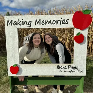 two girls standing in front of a sign that says making memories