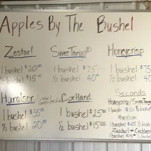 a whiteboard with a list of apples by the bushel