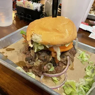 a hamburger with onions and lettuce