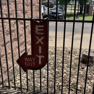 an exit sign attached to a gate
