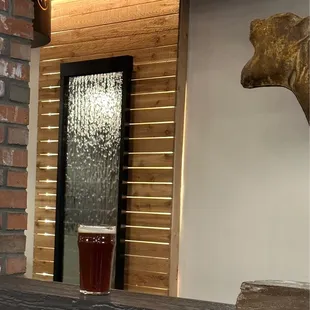a glass of beer in front of a brick wall