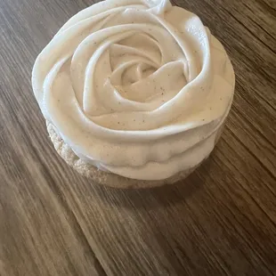 a frosted cupcake on a wooden table