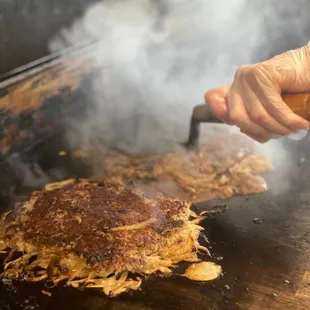 a person cooking a burger