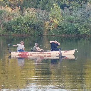 three men in a canoe on a lake