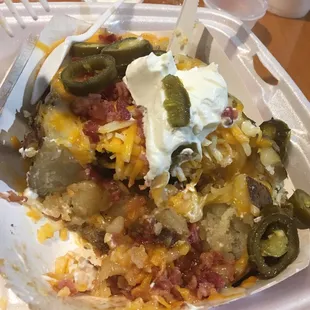 HUGE Brisket stuffed baked potato with cheese, bacon, butter, sour cream and jalapeños! For under $8.  This is the remaining half