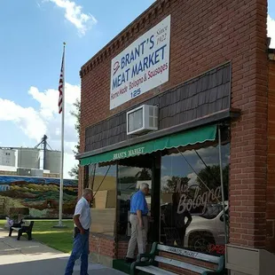 two men standing in front of a store
